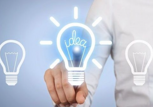 Persoon in wit overhemd wijst naar verlichte gloeilamp met 'idea', omringd door vier niet-verlichte lampen op blauwe achtergrond.