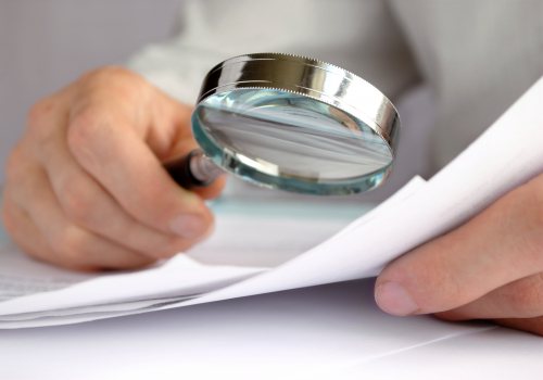 Medewerker bekijkt rapport met vergrootglas