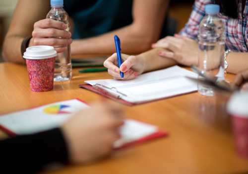 Collega's vullen documenten in aan tafel