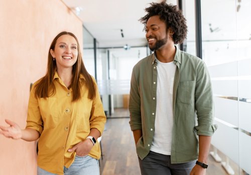 Twee collega's enthousiast met elkaar in gesprek op de gang