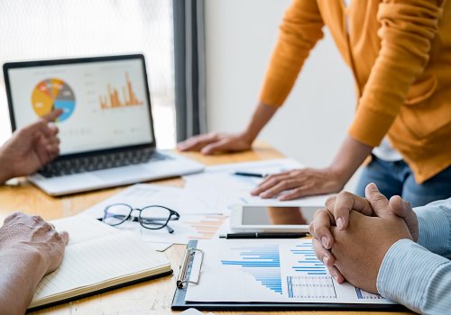 Collega's bekijken onderzoekscijfers op laptop