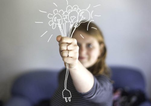 Persoon houdt een getekende bos bloemen met gloeilampen vast, waarvan de steel eindigt in een stekker.