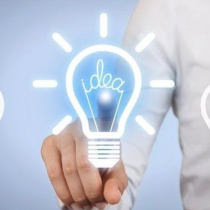 Persoon in wit overhemd wijst naar verlichte gloeilamp met 'idea', omringd door vier niet-verlichte lampen op blauwe achtergrond.