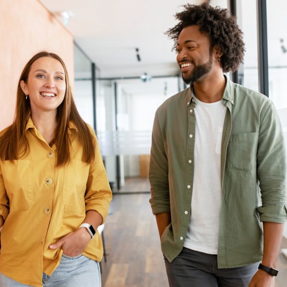 Twee collega's enthousiast met elkaar in gesprek op de gang