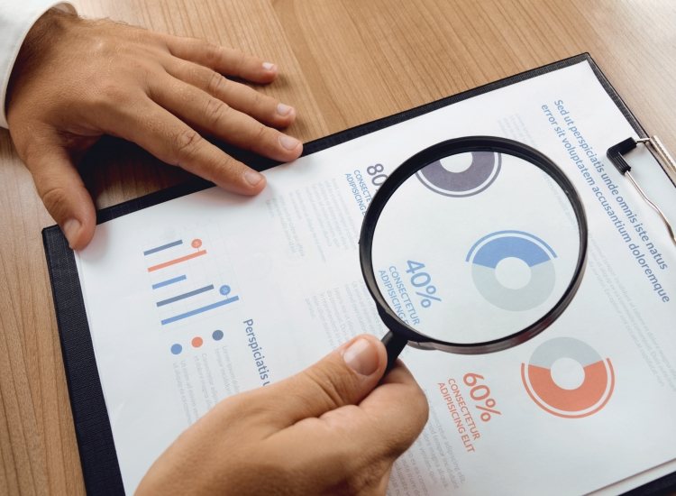 Medewerker bekijkt analyse met vergrootglas