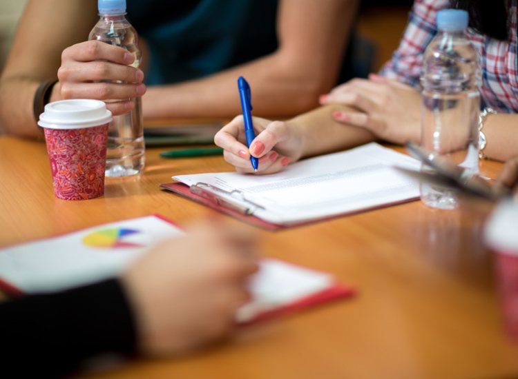 Collega's vullen documenten in aan tafel
