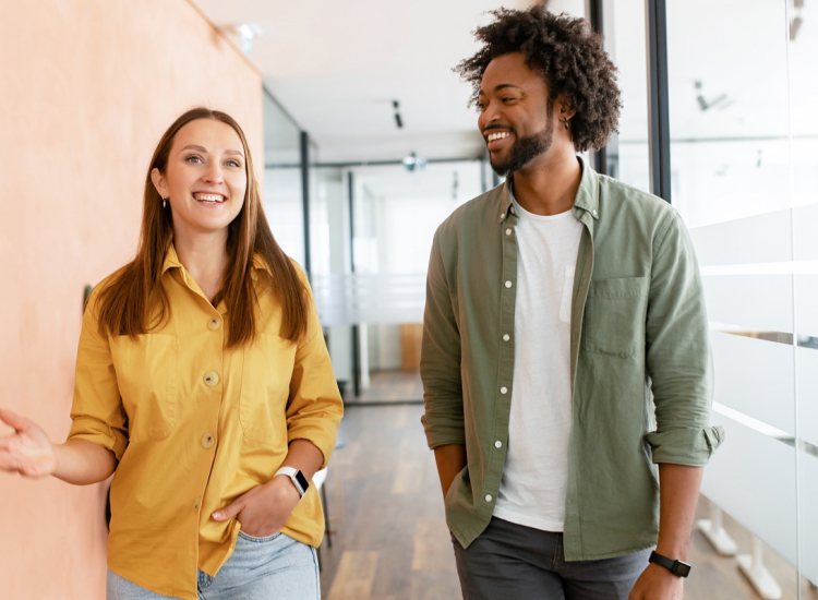 Twee collega's enthousiast met elkaar in gesprek op de gang
