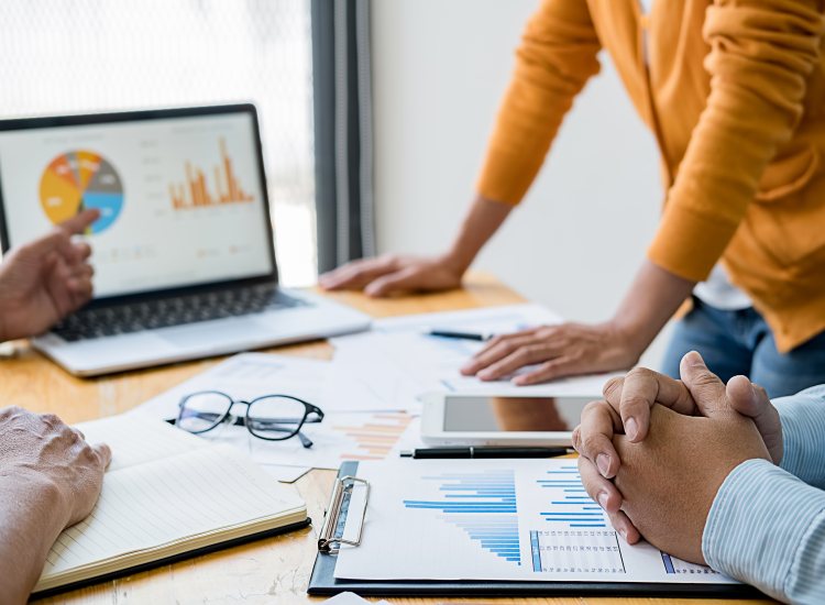 Collega's bekijken onderzoekscijfers op laptop