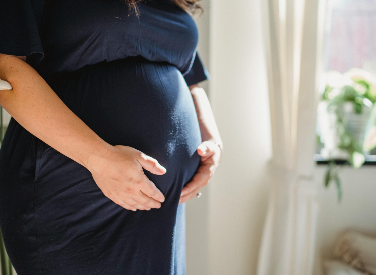 Zwangere vrouw met handen op buik