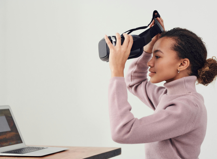 Vrouw achter laptop met vr-bril