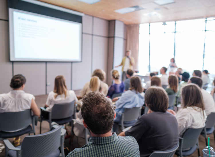 Mensen kijken in een zaal naar een presentatie