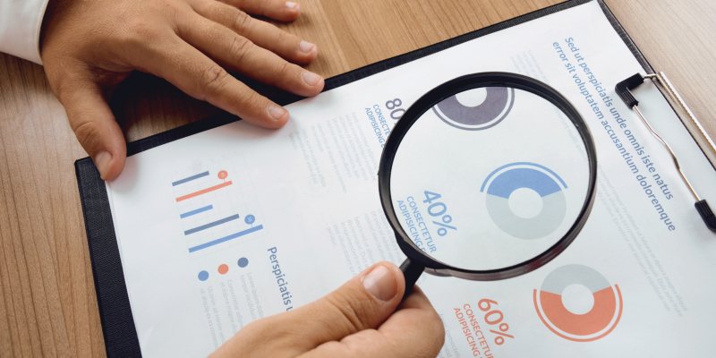 Medewerker bekijkt analyse met vergrootglas